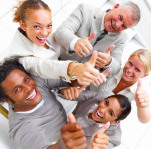 Laughing businesspeople showing thumbs up sign